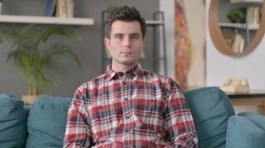 Kameraya, kanepeye bakan adamın portresi 