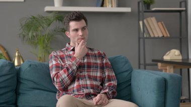 Koltukta oturan adam düşünüyor.