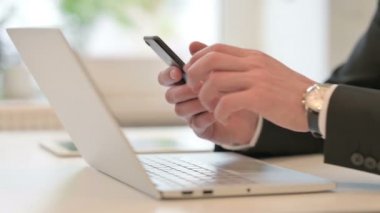 Close up of Middle Aged Businessman using Smartphone and Laptop 
