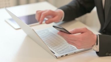 Top View of Middle Aged Businessman using Smartphone and Laptop 