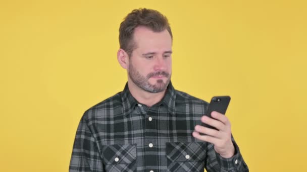 Retrato de homem de meia-idade reagindo à perda em Smartphone — Vídeo de Stock