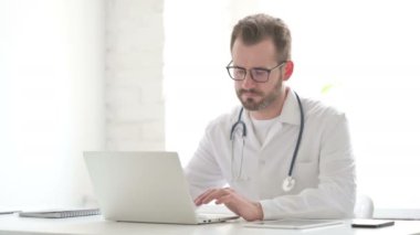 Doctor Working on Laptop in Office