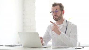 Doctor Talking on Video Call on Laptop in Office