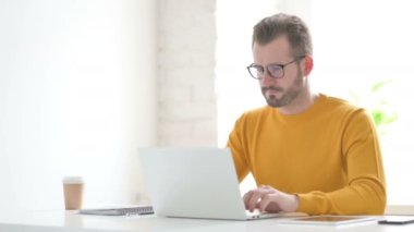 Ofiste dizüstü bilgisayar kullanırken öksüren adam 
