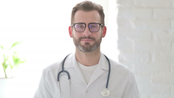 Portret van een aantrekkelijke dokter glimlachend naar de camera — Stockvideo