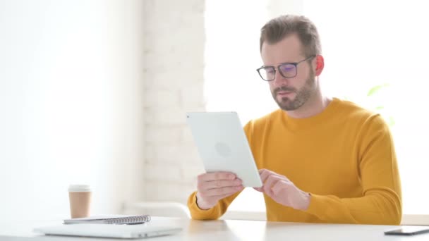 Homme réagissant à la perte sur tablette au bureau — Video