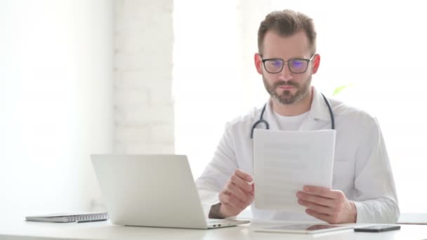 Doctor Reading Documents while Sitting in Office — Video Stock