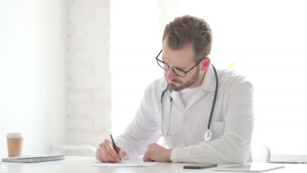 Läkare tänker medan du skriver på papper i Office — Stockvideo