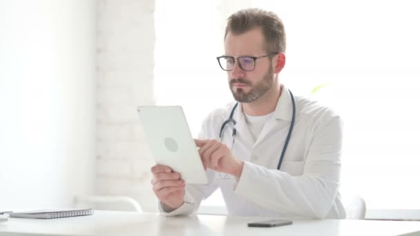 Γιατρός που χρησιμοποιεί Tablet ενώ κάθεται στο γραφείο — Αρχείο Βίντεο