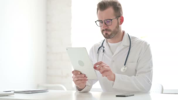 Lekarz korzystający z tabletu podczas siedzenia w biurze — Wideo stockowe