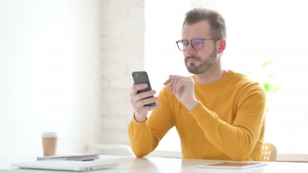 Uomo attraente utilizzando Smartphone in ufficio — Video Stock
