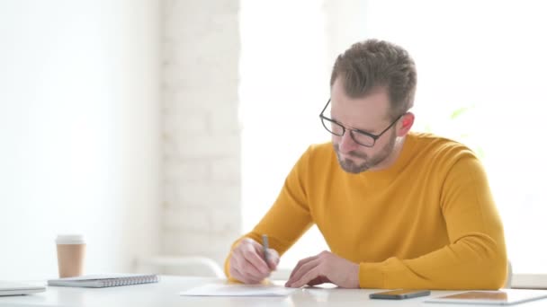 Un bărbat dezamăgit în timp ce scrie pe hârtie — Videoclip de stoc