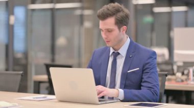 Ofiste dizüstü bilgisayar kullanırken Sırt Ağrısı çeken İşadamı