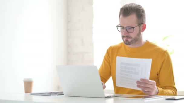 Man with Laptop Celebrating Success while Reading Documents — Stock video