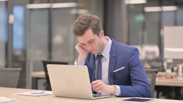 Homme d'affaires fatigué de faire la sieste tout en étant assis au bureau avec ordinateur portable — Video