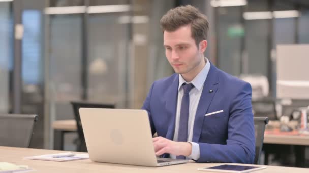 Geschäftsmann feiert Erfolg mit Laptop im Büro — Stockvideo