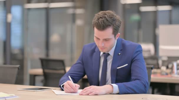 Zakenman Schrijven op papier in kantoor — Stockvideo