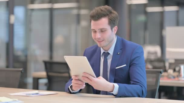 Homme d'affaires faisant appel vidéo sur tablette dans le bureau — Video