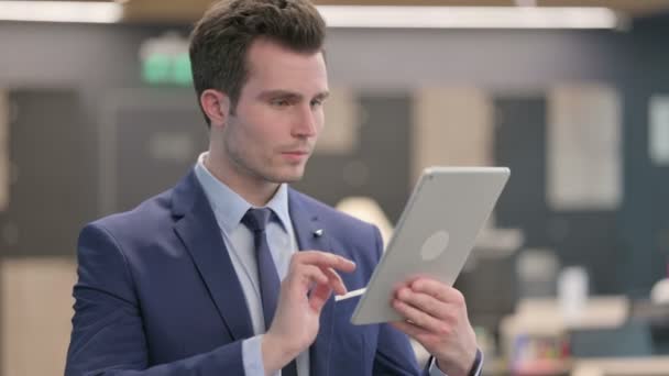 Retrato del hombre de negocios celebrando en la tableta en la oficina — Vídeo de stock