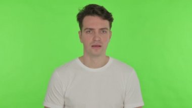 Yeşil arka planda öksüren genç adam kendini kötü hissediyor. 