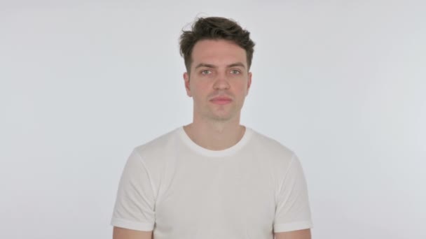 Uitnodigende jonge man wijzen op camera op witte achtergrond — Stockvideo