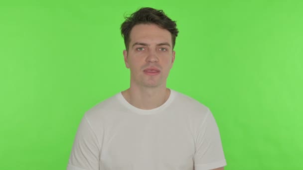 Zívající mladý muž na zeleném pozadí — Stock video