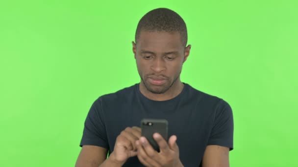 Homem Africano Jovem Navegando Smartphone em Fundo Verde — Vídeo de Stock