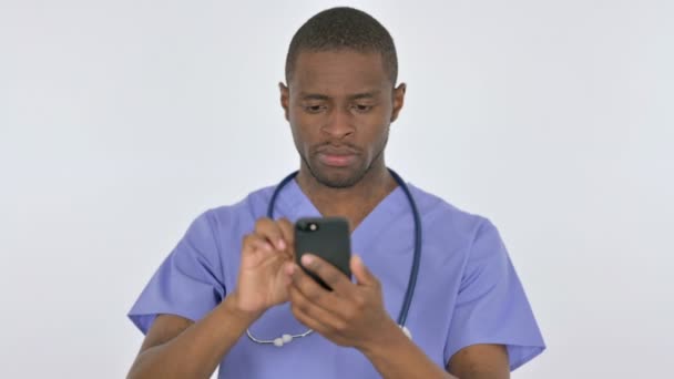 Африканский врач просматривает смартфон на белом фоне — стоковое видео