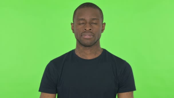 초록색 배경에 있는 진지 한 젊은 아프리카 남자 — 비디오