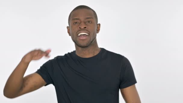 Молодой африканский человек оглядывается, ища на белом фоне — стоковое видео