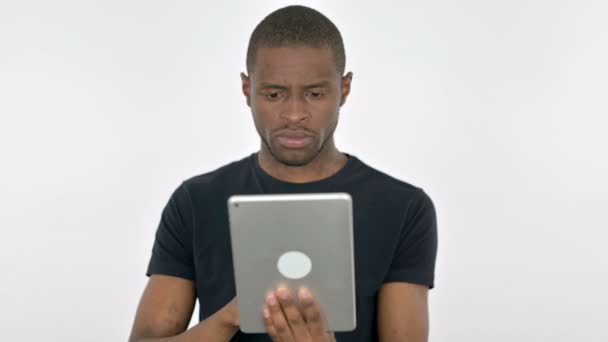 Jeune homme africain réagissant à la perte sur tablette sur fond blanc — Video