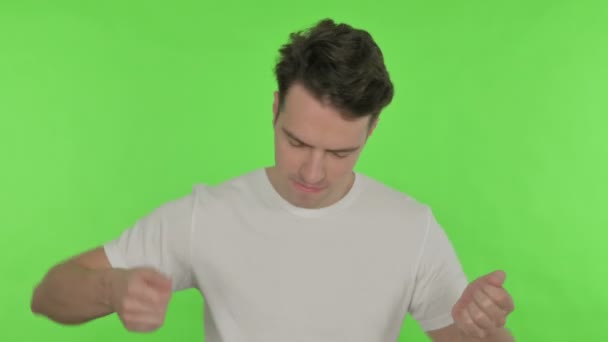 Glücklicher junger Mann tanzt auf grünem Hintergrund — Stockvideo