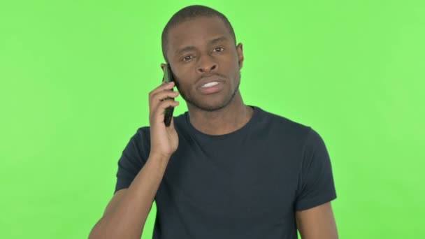 녹색 배경으로 전화 통화를 하는 젊은 아프리카 남자 — 비디오