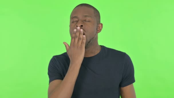 Bocejando jovem homem africano no fundo verde — Vídeo de Stock