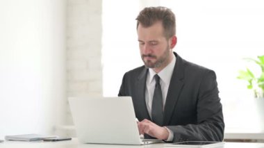 Genç İşadamı dizüstü bilgisayarla uğraşırken baş ağrısı çekiyor