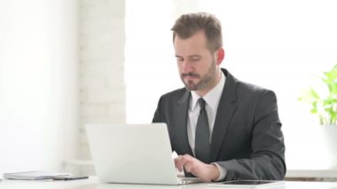 Ofiste dizüstü bilgisayar kullanırken Sırt Ağrısı çeken Genç İşadamı 