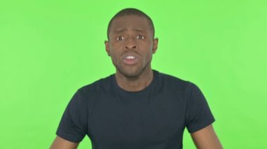Hayal kırıklığına uğramış Afrikalı Adam Yeşil Arkaplanda Kaybına Tepki Veriyor 
