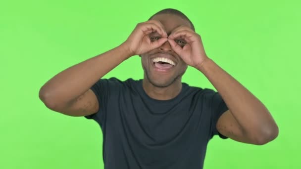 Afrikanischer Mann Mit Fernglas Geste Auf Grünem Hintergrund Gesucht — Stockvideo