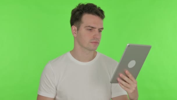 Nenucený Mladý Muž Slaví Úspěch Tabletu Zeleném Pozadí — Stock video