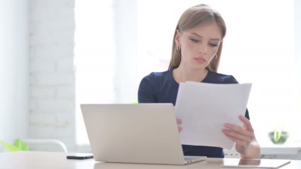 オフィスでノートパソコンの読書文書を持つ若い女性 — ストック動画
