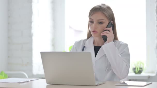 Médecin Féminin Parlant Téléphone Tout Travaillant Sur Ordinateur Portable — Video