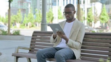 Afro-Amerikan Adam Tablet 'te Kaybına Tepki Verirken Benç' te oturuyordu.