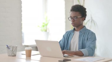 Ofiste Dizüstü bilgisayar kullanan Afrikalı Adam Başparmağını kaldırdı 