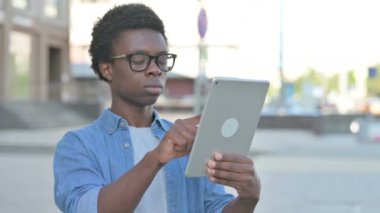 Portrait of African Man using Digital Tablet Outdoor
