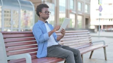 Bench 'te otururken Tablet' te Online Zaferi Kutlayan Afrikalı Adam