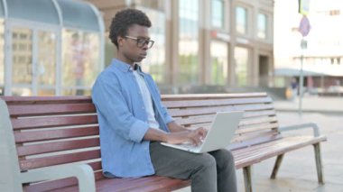 Busy African Man Using Laptop Sitting Outdoor on Bench