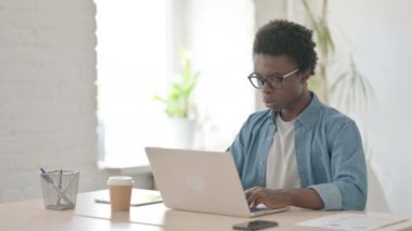 Ofiste dizüstü bilgisayar kullanırken Afrikalı Adam Başarı Kutlaması