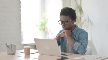 Ofisteki dizüstü bilgisayarda çalışırken düşünen Afrikalı adam