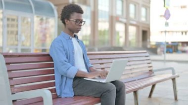 Man Pointing at the Camera while Sitting on Bench Outdoor