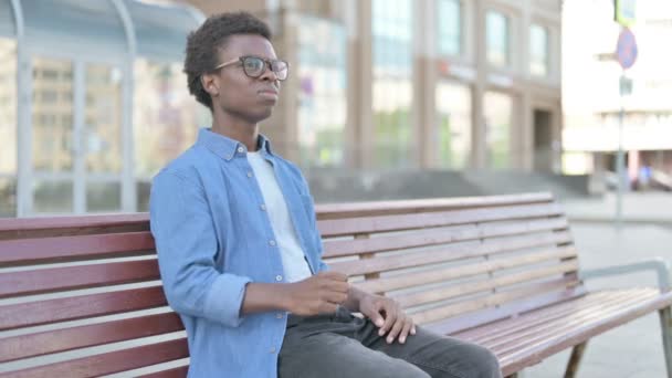 Angespannter Afrikanischer Mann Fühlt Sich Frustriert Während Draußen Auf Bank — Stockvideo